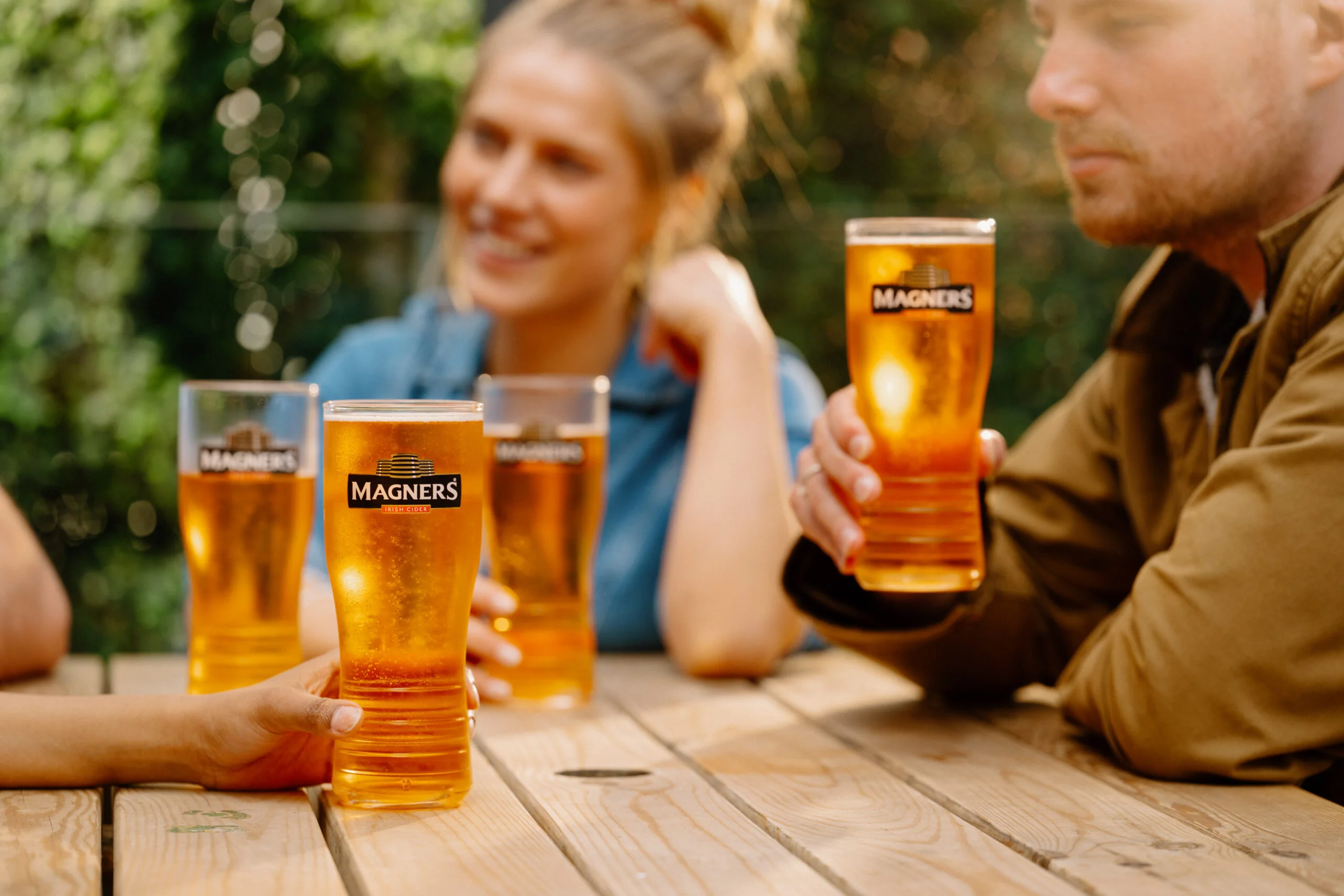 People saying cheers holding Magners Irish Cider